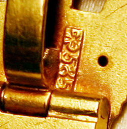 Auf der Rückseite am Scharnier der Aufhängung geprägte Punze mit dem dreiblättrigen Kleeblatt und dem Goldstempel. Foto: Robert Gotzmann.